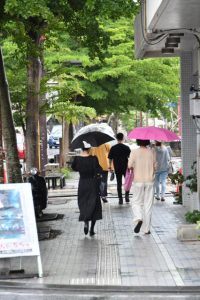 雨の中、傘を差して歩く人たち＝４日、平良西里