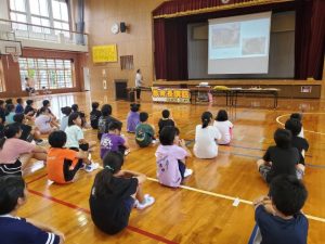 池城教育長（奥）が八月踊りについて講話した＝５日、多良間小体育館