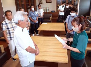 多良間会長（手前右）から要請書が座喜味市長に手渡された＝7月31日、市役所