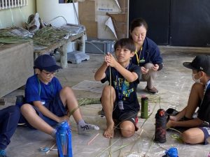 ススキを使って縄ない体験を楽しんだ子供たち＝20日、市総合博物館