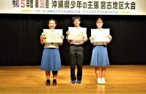 最優秀賞の下地さん（中央）と優秀賞の友利さん（右）、渡真利さん（左）＝9日、市未来創造センター多目的ホール