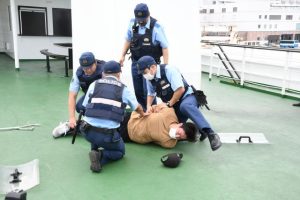 不審者を展望デッキに追い詰めて制圧、逮捕する警察官ら＝20日、ベイクルーズ宮古島モンブラン