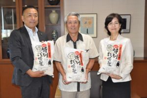 立山さん（左）から座喜味市長（中央）、大城教育長に米が寄贈された＝10日、市役所