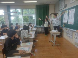 郵便局員が年賀状の書き方を説明した＝22日、久松小学校