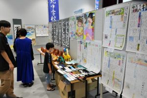 中学生の力作を見つめる来場者ら＝４日、市未来創造センター研修棟