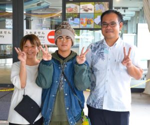 北海道から帰島した堅真さん（中央）と母親の美香さん（左）、根間学院長＝16日、下地島空港