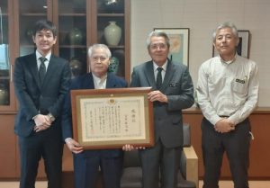 法務大臣感謝状受賞を報告した宮里さん（左から２人目）＝20日、市役所