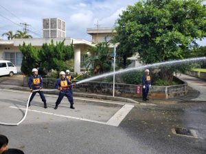 無災害を願い一斉に放水する団員ら＝9日、村コミュニティー施設