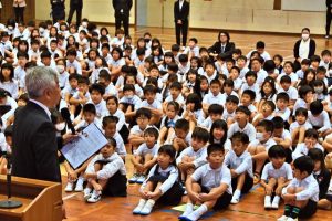  能登半島の地震で被災した人たちの気持ちに寄り添うことの大切さを與那覇校長が呼び掛けた始業式＝9日、平良第一小体育館