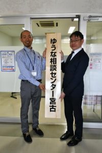 「ゆうな相談センター宮古」の看板を掲げる山田課長（右）と荷川取さん＝14日、県宮古合同庁舎