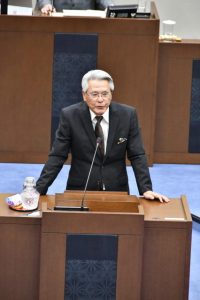 度重なる追加議案提出で謝罪する座喜味市長＝19日、市議会議場