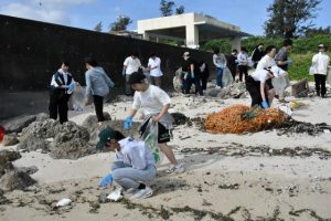 ペットボトルなどのごみを拾い集める生徒たち＝１６日、高野海岸