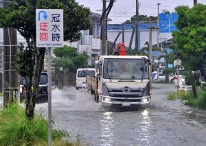 平良下里などで７２時間降水量が観測史上最多を記録。写真は冠水した道路を水しぶきを上げ走行する車両＝２３日、平良