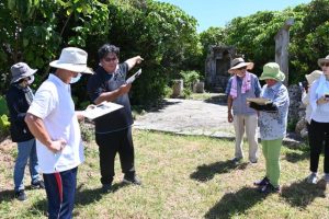 久貝さん（左から3人目）の説明を受けながら戦争遺跡について理解を深めた参加者ら＝15日、池間尋常小学校奉安殿