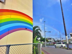 空の虹と壁に描かれた虹がつながる風景が見られた＝８日、市内