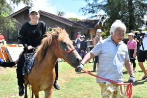 乗馬体験に笑顔を見せる参加者＝2日、宮古島熱帯果樹園まいぱり