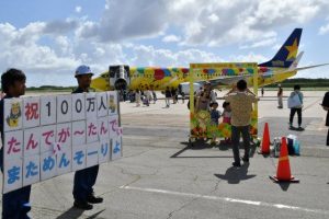 関係者らがメッセージボードを手に搭乗客を見送った＝12日、下地島空港