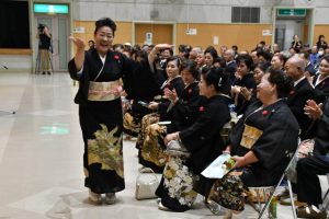 名前を呼ばれた後、踊り出す新敬老者＝16日、伊良部公民館