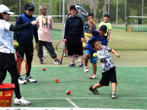 レッスンを楽しむ小学生たち＝23日、カママ嶺テニスコート