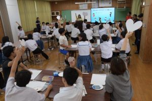 切り取ったそれぞれの「ハート」を掲げる生徒たち＝５日、下地中学校