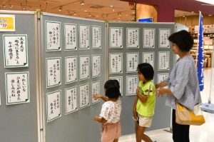 展示された作品に見入る来店者＝16日、サンエー宮古島シティ