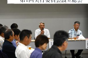 総会で議案を審議する座喜味委員長（左奥）＝28日、市役所