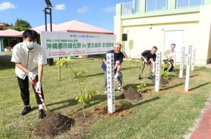 記念植樹を行う座喜味市長（左から２人目）ら関係者＝18日、パイナガマ海空すこやか公園