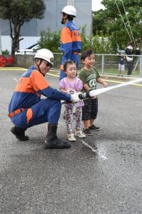 消防署員の指導を受け放水を体験する子どもたち＝９日、市消防本部