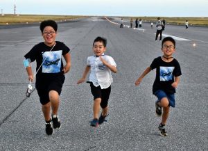 広大な滑走路で走り出す子どもたち＝９日、下地島空港