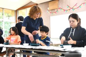 児童、職員が香山さん（中央）の指導で焼き物作りに取り組んだ ＝24日、福嶺小学校