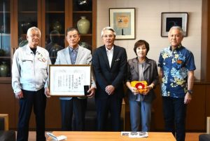 緑白綬有功章を受章した砂川寛裕さん（左から２人目）、和子さん（右から２人目）と関係者の皆さん＝２日、市役所