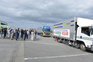 島産野菜の初出荷を「万歳三唱」で見送る関係者ら＝８日、ＪＡおきなわ宮古地区農産物集出荷施設