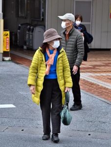 寒さ対策として暖かい服装で身を包む市民＝10日、市内スーパー