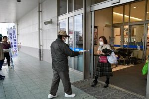 買い物客らにチラシを配布し、選挙をアピールした＝13日、サンエー宮古島シティ店