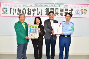 新垣署長（右）、前川会長（左）から前泊教育長職務代理者（左２人目）と久貝順一教育部長（同３人目）に筆記具が贈られた＝３日、市役所